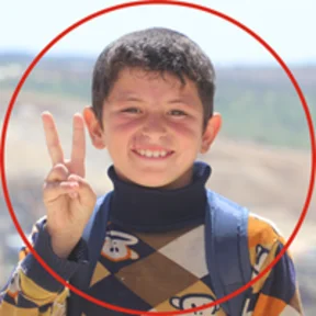 ch1820711-kareem-9-smiles-at-the-camera-on-his-way-to-school.png