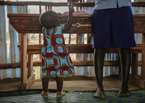 CH1542620-Mary-16-plays-with-her-daughter-at-school-in-a-refugee-settlement-in-West-Nile-Uganda