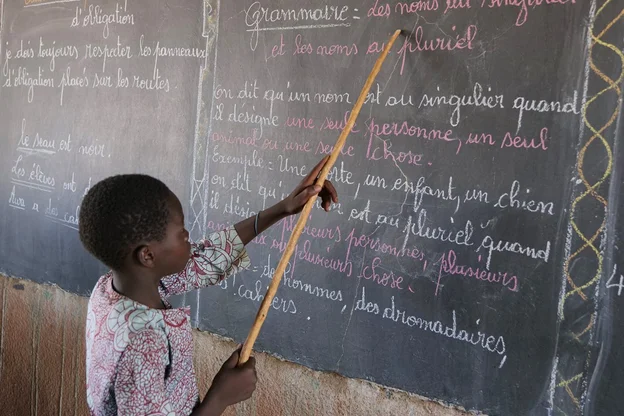 CH1545245-Souleymane-aged-14-points-to-words-on-a-blackboard-at-school-Yatenga-province-Burkina-Faso