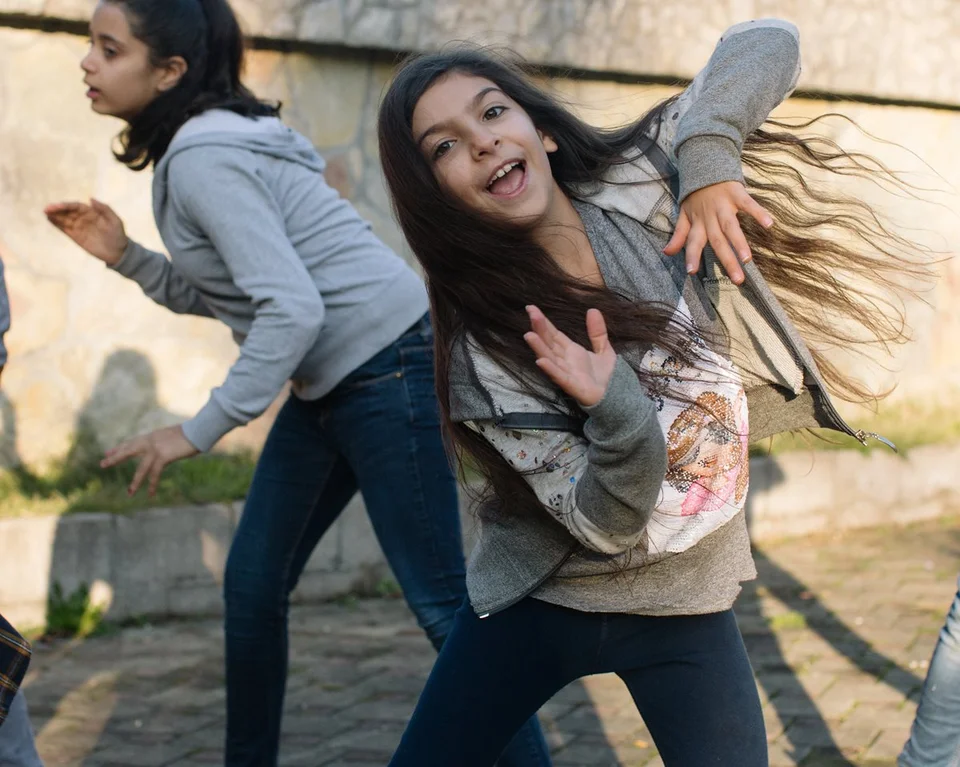 CH1400218-Furugh-9-and-her-friend-dance-outside-at-the-refugee-camp-where-they-live.aspx%3Fwidth%3D1200%26height%3D959%26ext%3D.jpg.webp