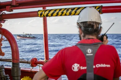CH128955-A-Save-the-Children-team-member-looks-out-at-a-boat-crowded-with-refugees-and-migrants-in-the-Mediterranean-Sea.png CH128955-A-Save-the-Children-team-member-looks-out-at-a-boat-crowded-with-refugees-and-migrants-in-the-Mediterranean-Sea.png