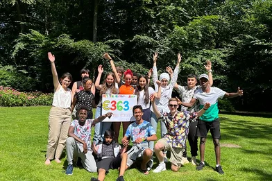 Groep adolecenten juigen, houden bord vast met tekst: €363,-