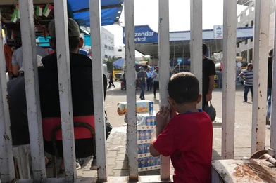 Een kind staat achter een hek in Gaza