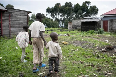 Drie broers lopen in het vluchtelingenkamp aan de rand van Goma in DRC